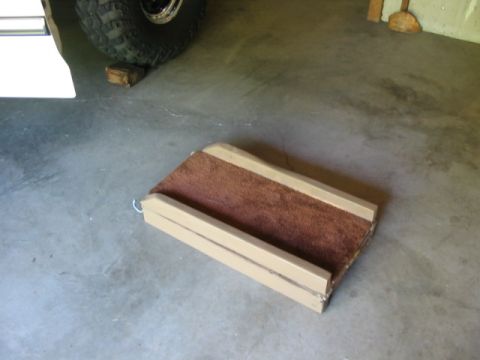 1995 Ford Bronco - A dog ramp is positioned near the tire of a vehicle on a concrete floor.