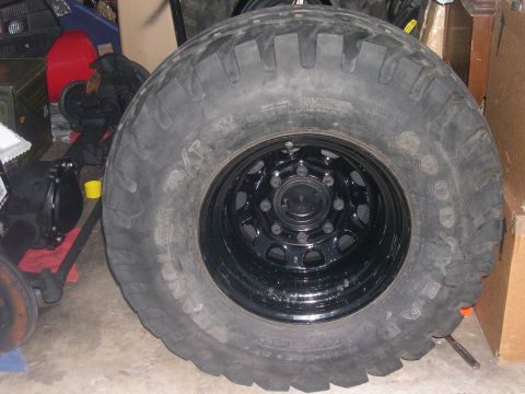 1980 Chevrolet Blazer - A close-up view of a large tire and rim, likely for an off-road vehicle, is shown indoors.