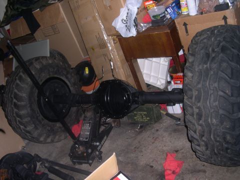 1980 Chevrolet Blazer - Rear axle assembly with large tires, likely for an off-road vehicle, stored indoors.