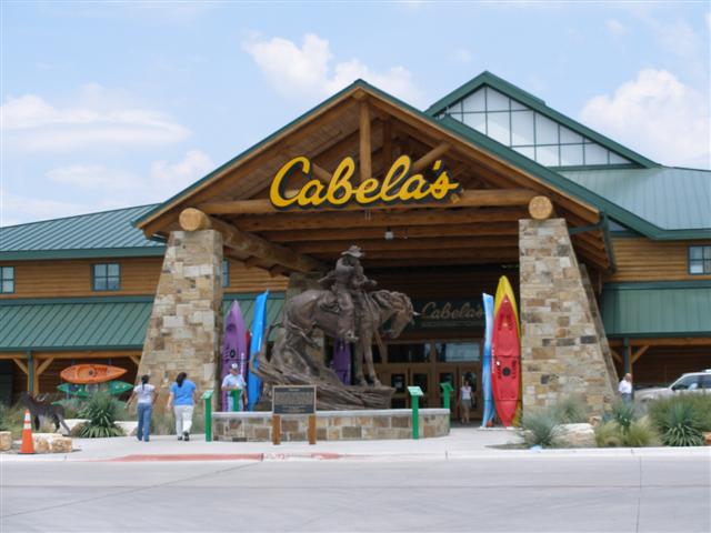 Cabela's storefront with log entrance, bronze horse-and-rider statue and kayaks lined out front