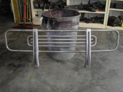 1995 Jeep YJ - A chrome brush guard is shown in front of a large trash can and shelves with parts.