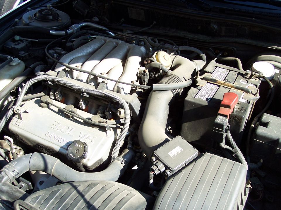 3.0L 24-valve V6 engine bay with intake manifold, plug wires and battery