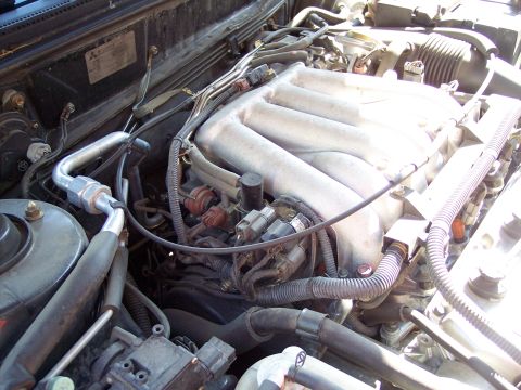 1995 Ford Probe - Close-up view of an engine bay, showing the intake manifold, AC lines, and various engine components.
