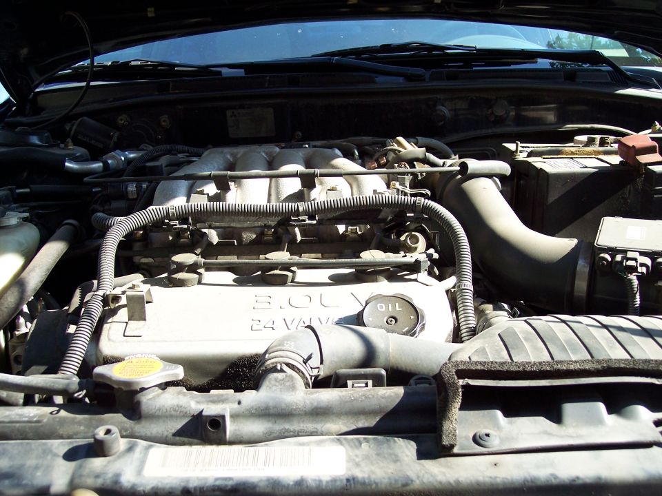 Engine bay with 3.0L 24 valve engine cover and oil cap visible