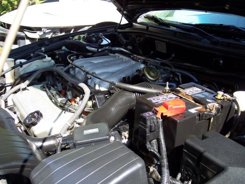 1995 Ford Probe - Close-up view of a car's engine bay, showing the battery and intake system.