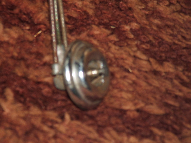 chrome knob with a cable attached, against a brown textured background