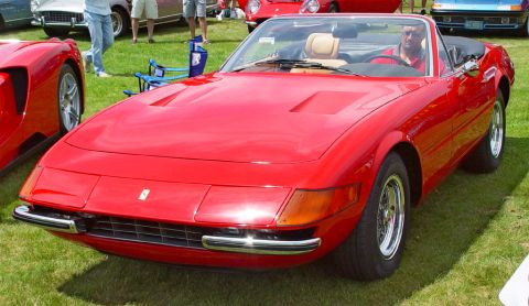 1991 Ford Taurus - This red convertible features pop-up headlights and a tan interior, seen at an outdoor car show.