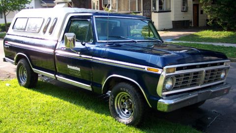 1975 Ford F-150 - This Ford F-150 pickup truck features a two-tone paint scheme with a white camper shell and chrome accents.