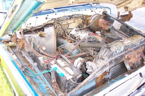 1975 Ford F-150 - The engine bay of a 1975 Ford F-150 shows significant rust and deterioration.