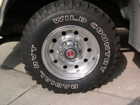 1994 Ford Bronco - A close-up view of a tire and wheel assembly on a vehicle.