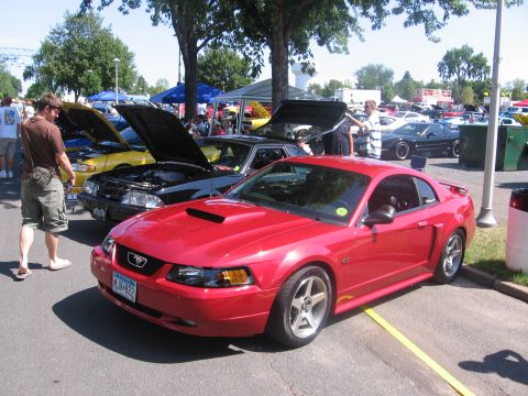1989 Ford Mustang - Red Ford Mustang GT with hood scoop and GT badging at a car show.