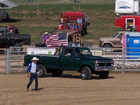 1972 Ford Ranchero - Green Ford pickup truck with American flag and company decal on tailgate.