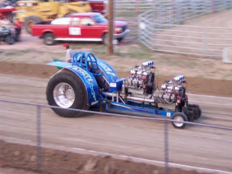 1972 Ford Ranchero - A modified tractor with dual engines competes in a pull event, with other vehicles visible in the background.