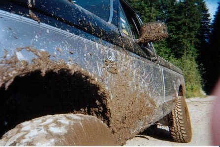 1995 Ford F-150 - This truck is heavily covered in mud after driving off-road.