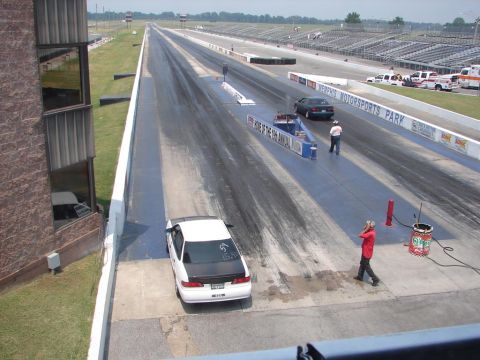 1992 Ford Taurus - A white 1992 Ford Taurus is parked on the starting line of a drag strip.