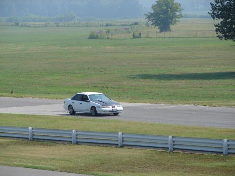 1992 Ford Taurus - A white 1992 Ford Taurus with a contrasting black hood is seen on a race track.
