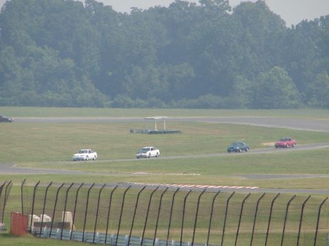 1992 Ford Taurus - Cars are seen on a race track with a wooded area behind them.