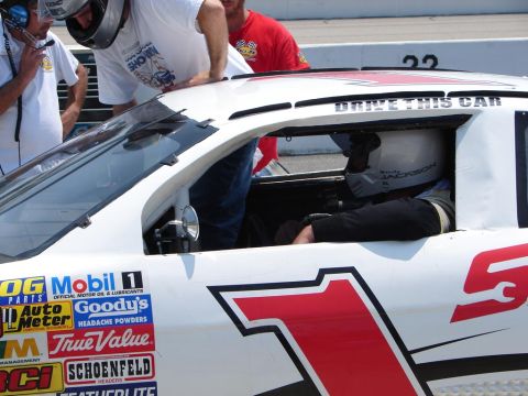 1992 Ford Taurus - A race car with numerous sponsor decals is prepared for the track.