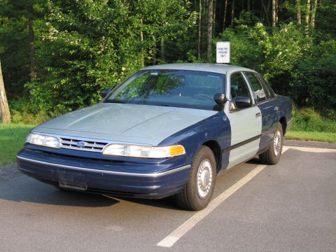 1991 Ford LTD Crown Victoria - This Ford Crown Victoria has a two-tone paint job and is parked in a designated spot.