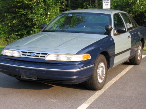 1991 Ford LTD Crown Victoria - This Ford Crown Victoria has a two-tone paint job and is parked in a designated spot.