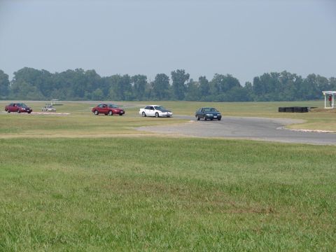 1992 Ford Taurus - Multiple sedans are seen on a race track during a convention.