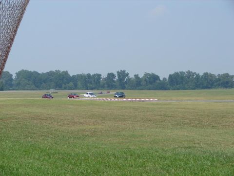 1992 Ford Taurus - Cars are seen on a race track on a clear day with a grassy field in the foreground.