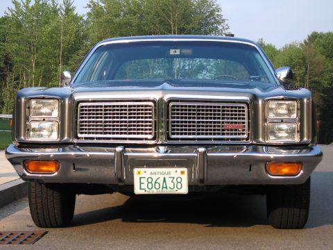 1991 Ford LTD Crown Victoria - This dark sedan features a prominent chrome grille and dual headlights, with a New Hampshire license plate visible.