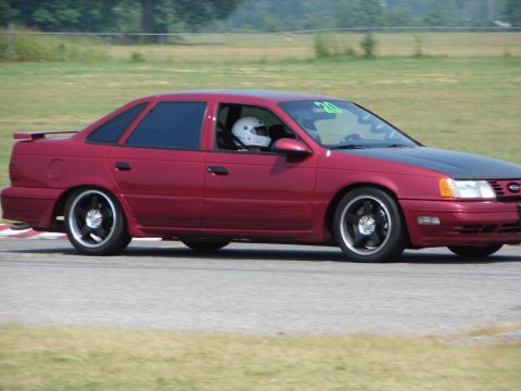 1992 Ford Taurus - This 1992 Ford Taurus is seen on a race track, a contrasting black hood and aftermarket racing wheels.