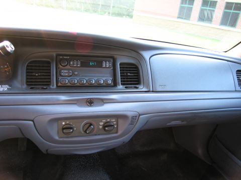 1991 Ford LTD Crown Victoria - The dashboard of a car features a radio, climate controls, and an airbag indicator.