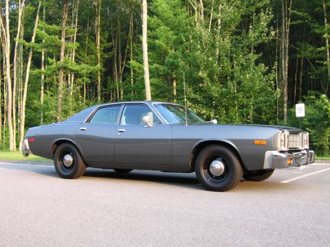 1991 Ford LTD Crown Victoria - Side view of a 1977 Dodge Monaco police car parked outdoors with a wooded background.