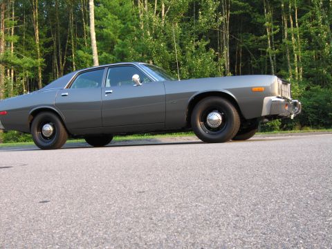 1991 Ford LTD Crown Victoria - A gray sedan is parked on a road with trees in the background.