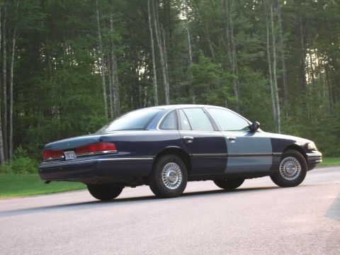 1991 Ford LTD Crown Victoria - Rear view of a two-tone 1991 Ford Crown Victoria LTD parked on a road with trees in the background.