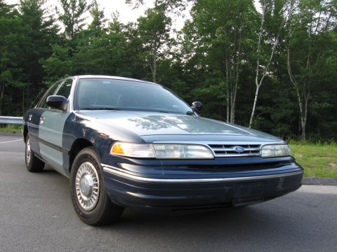1991 Ford LTD Crown Victoria - A two-tone Ford Crown Victoria is shown from the front three-quarter angle.