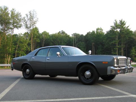 1991 Ford LTD Crown Victoria - This 1977 Dodge Monaco sedan, equipped with police lights, is shown from a 3/4 front angle.