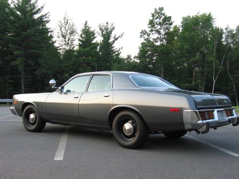 1991 Ford LTD Crown Victoria - This gray sedan, likely a 1977 Dodge Monaco, is shown from the rear three-quarter angle in a parking lot.