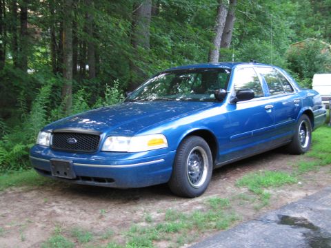 1991 Ford LTD Crown Victoria - A blue sedan is parked outdoors with trees and grass surrounding it.