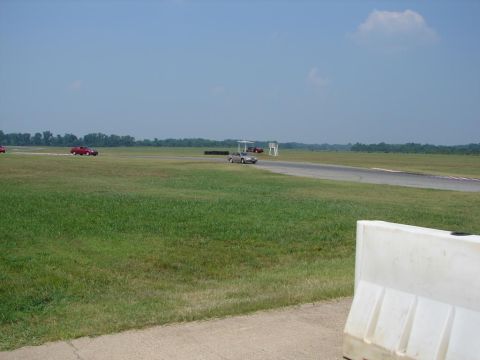 1992 Ford Taurus - Several vehicles are visible on a racetrack under a clear blue sky.