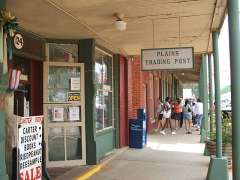 1966 Ford Ranchero - Exterior view of a store with a sign reading 'Plains Trading Post' and several people walking by.