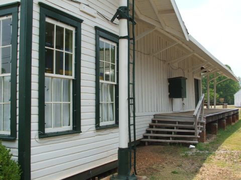 1966 Ford Ranchero - Exterior view of a white building with dark green trim around the windows and a covered porch with wooden stairs.