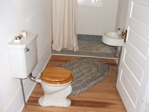 1966 Ford Ranchero - A bathroom scene includes a toilet, sink, and a woven rug on a wooden floor.