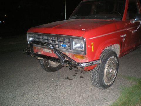 1985 Ford Bronco II - A red Ford Bronco II shows damage to its front bumper and bull bar.