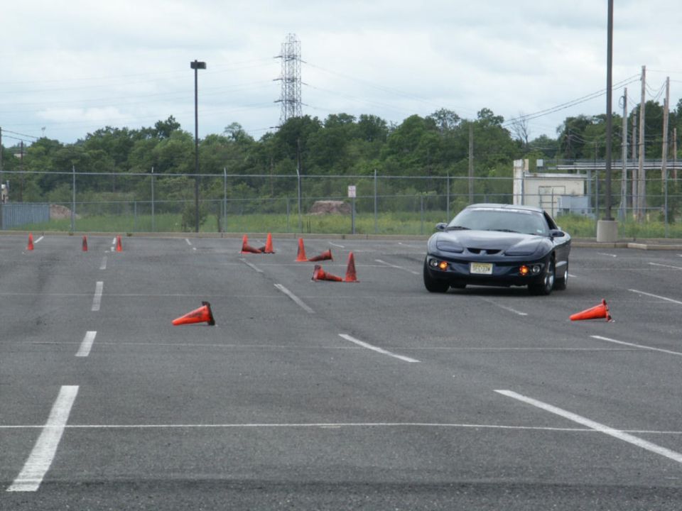 Dark blue sports car on a cone course