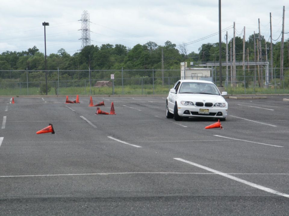 White BMW sedan on a cone course with a license plate reading 'FGM-322'