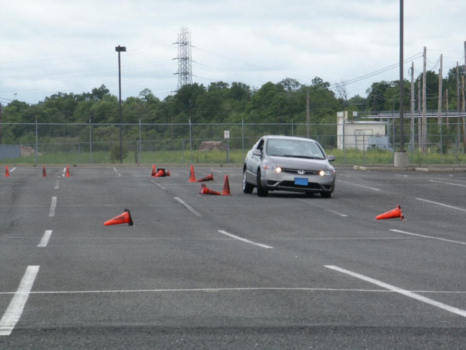 Silver Honda Civic driving through a cone course in a parking lot