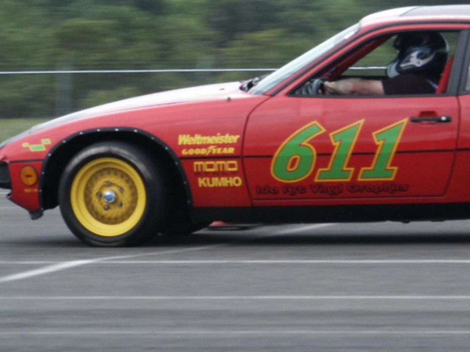 Red race car with yellow wheels, green 611 graphics, and sponsor decals