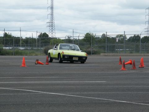 2001 Mercury Grand Marquis - A yellow sports car is seen maneuvering through a course marked by orange traffic cones on an overcast day.