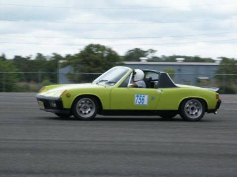 2001 Mercury Grand Marquis - A lime green Porsche 914 is seen on a track with a driver wearing a helmet.