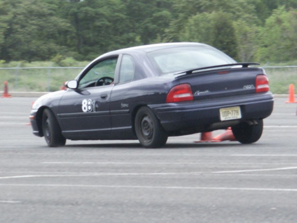 Dark blue Plymouth Neon coupe with number 88 on door, on a race track with orange cones