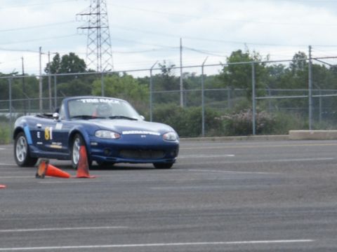 2001 Mercury Grand Marquis - A blue convertible sports car navigates a course marked by orange cones.