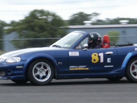 2001 Mercury Grand Marquis - Blue convertible race car with number 81 on the door is on the track.